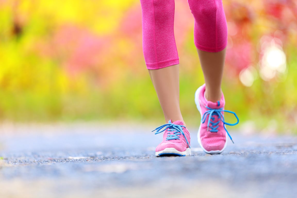 Legs of the walking women wearing sneakers.