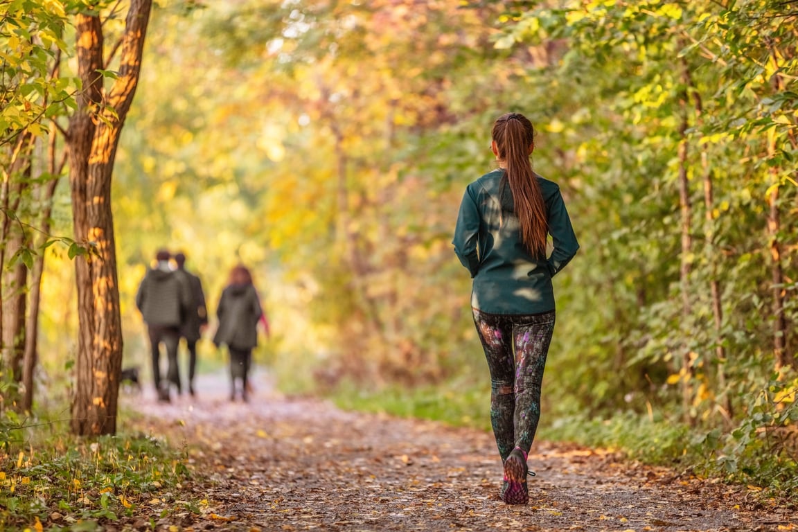 A woman is walking away in the park.