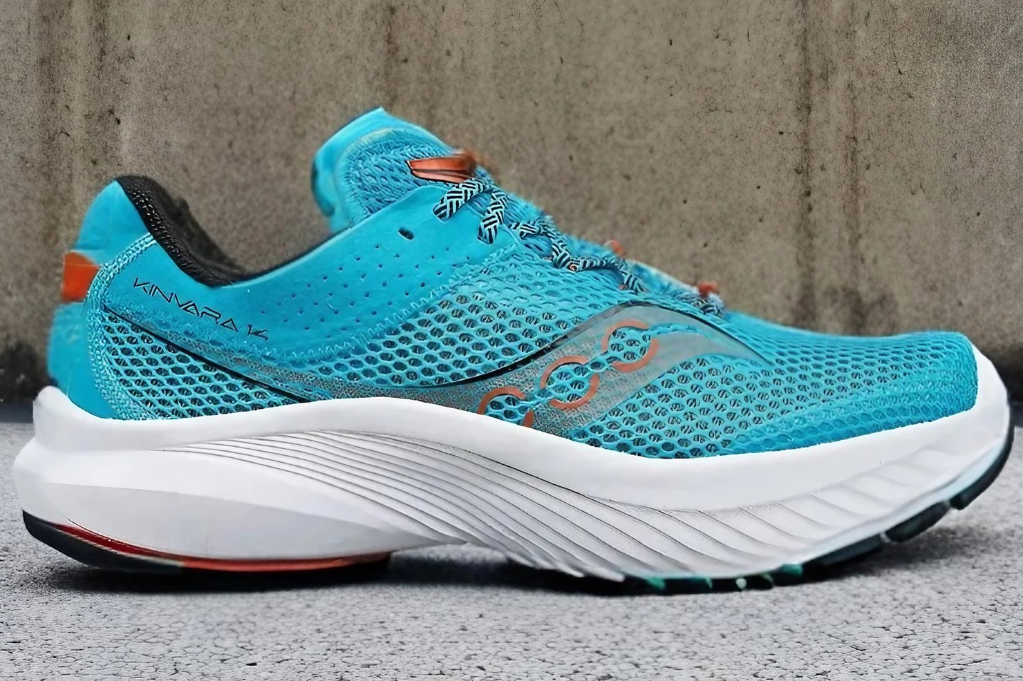 The Saucony Kinvara 14 in front of a rock wall.
