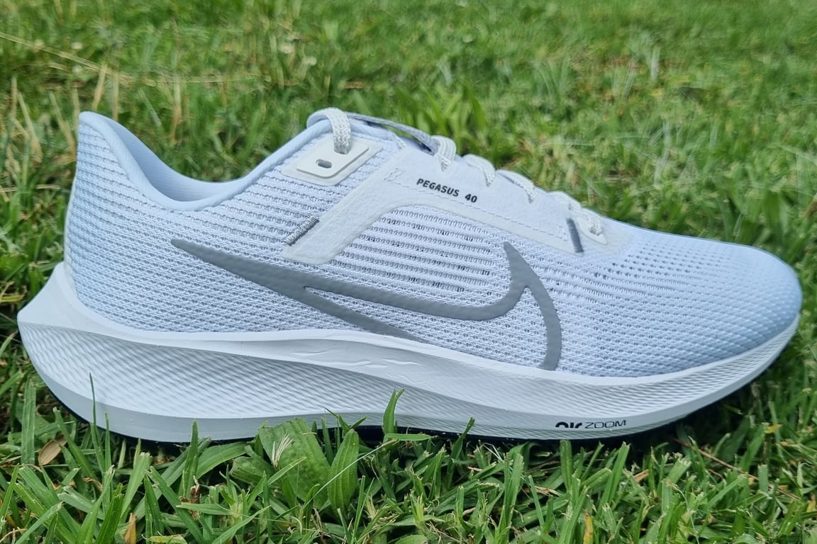 The white Nike Pegasus 40 on the grass.