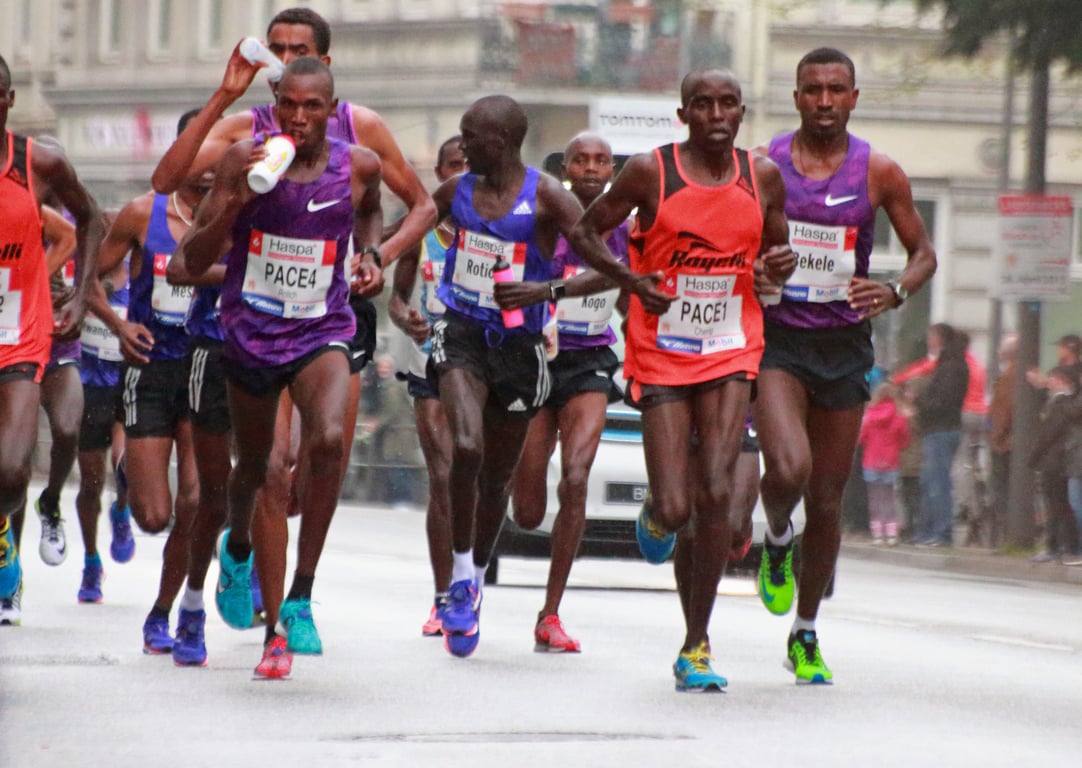 Skinny elite runners fueling during the race.