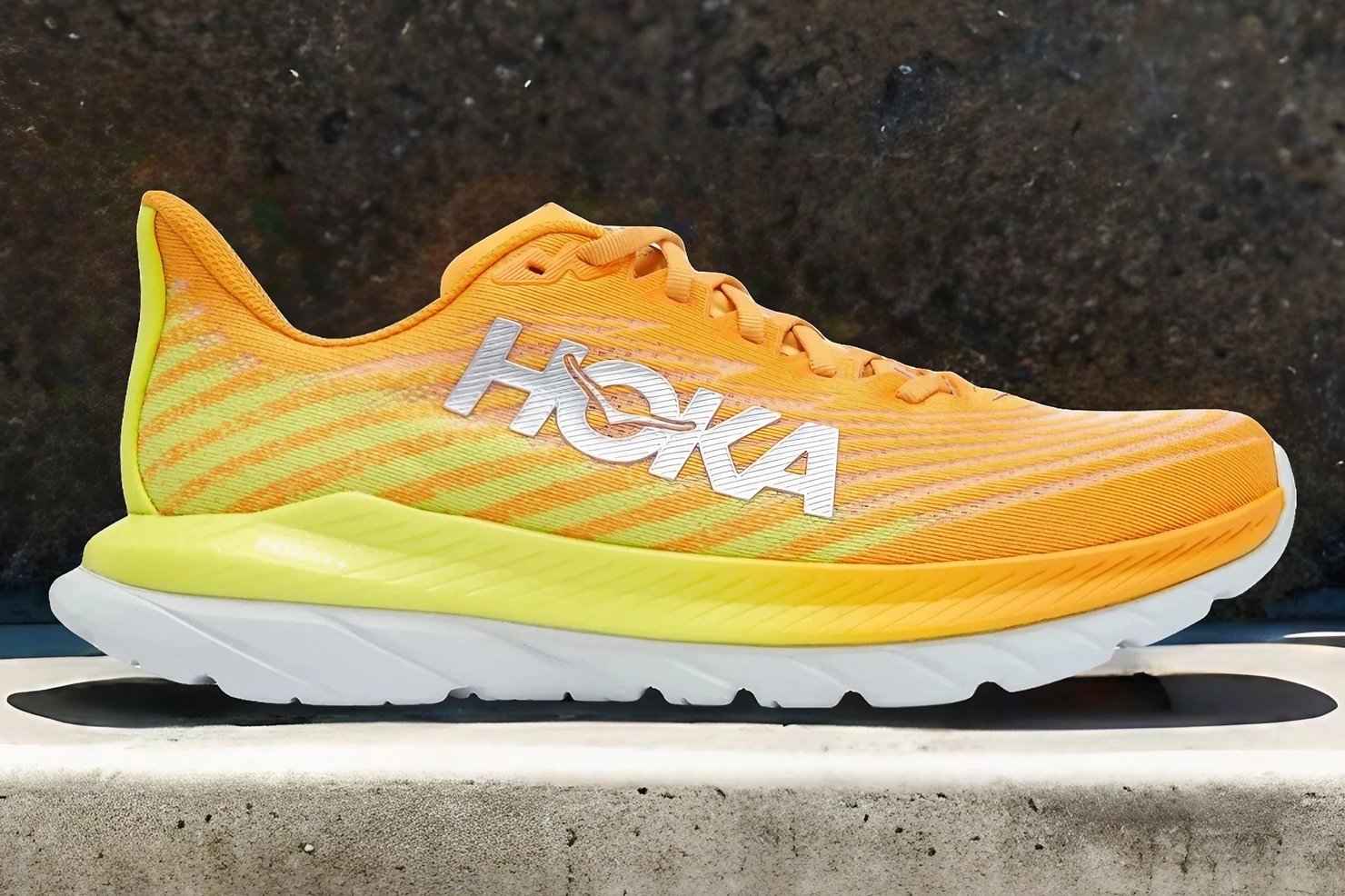 The Hoka Mach 5 in front of a rock wall.
