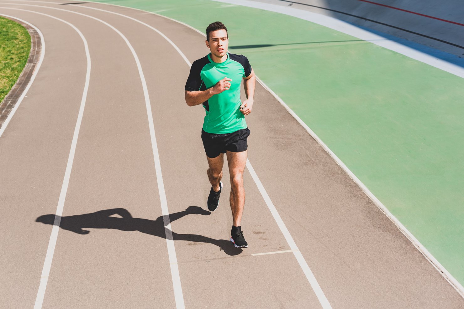 За 1 час спортсмен пробежал 8910 метров. Бегущие Атлет в бело зелёных тонах спиной. Спортсмен пробежал 8910 м.
