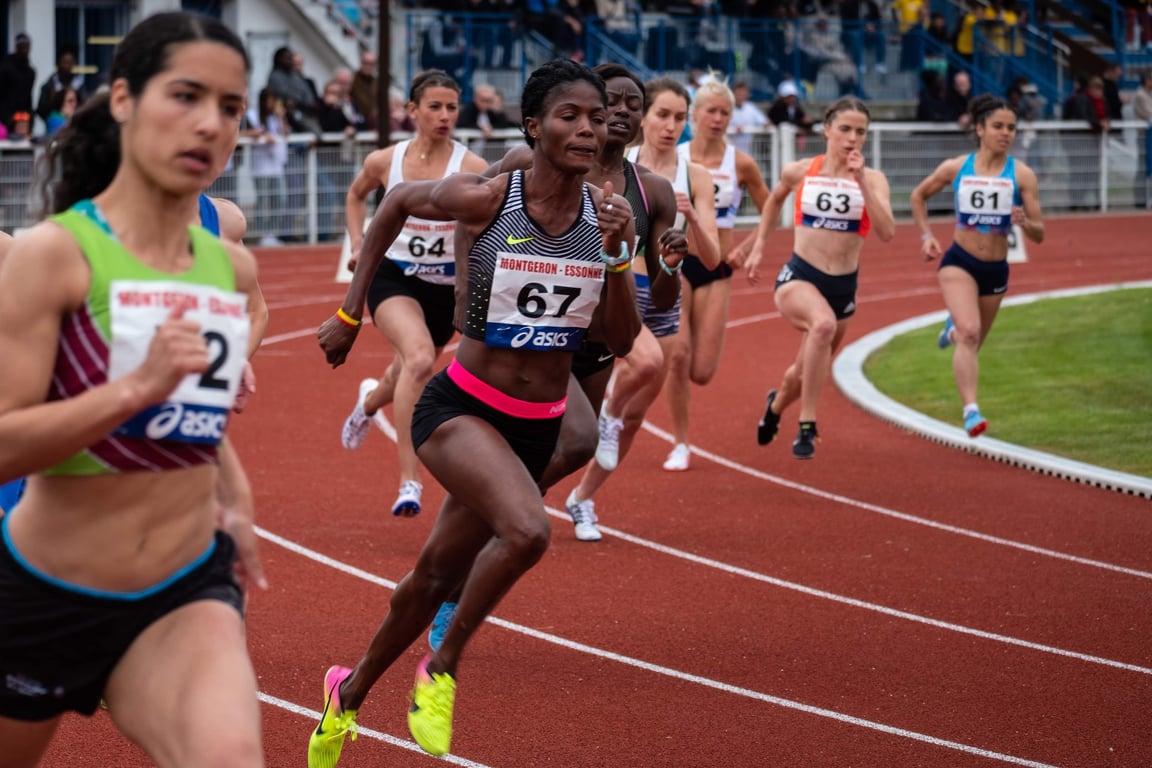 Elite woman athletes are racing on a track.