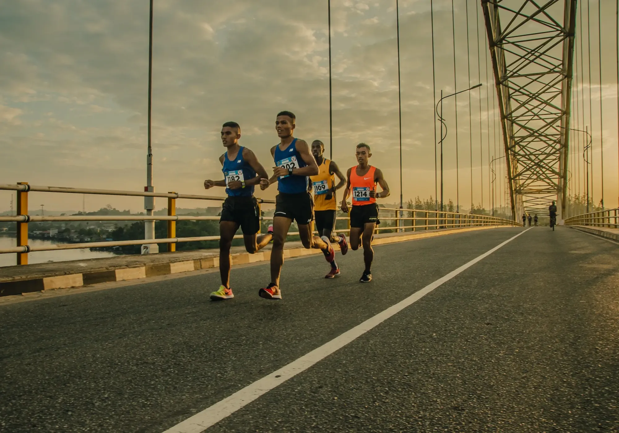 Professional runners on a bridge during a race.